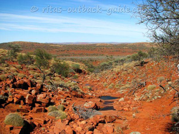 Colourful red gorge with small water pools