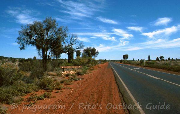 Outback road in Central Australia, bitumen in lined by red earth