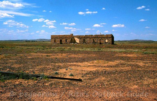 A ruin in the distance, and a piece of rail A ruin in the distance, and a piece of rail